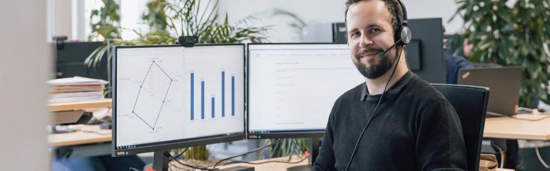 IT-Support Mitarbeiter von FIVE Informatik AG mit Headset am Arbeitsplatz